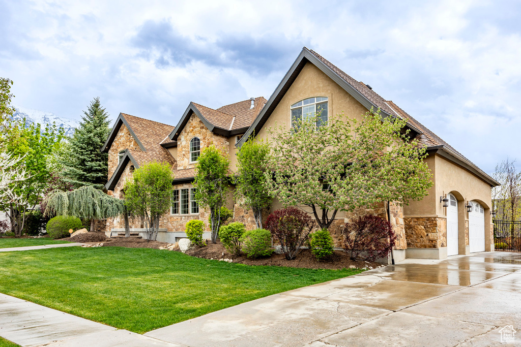 View of front of home featuring a front yard and a garage