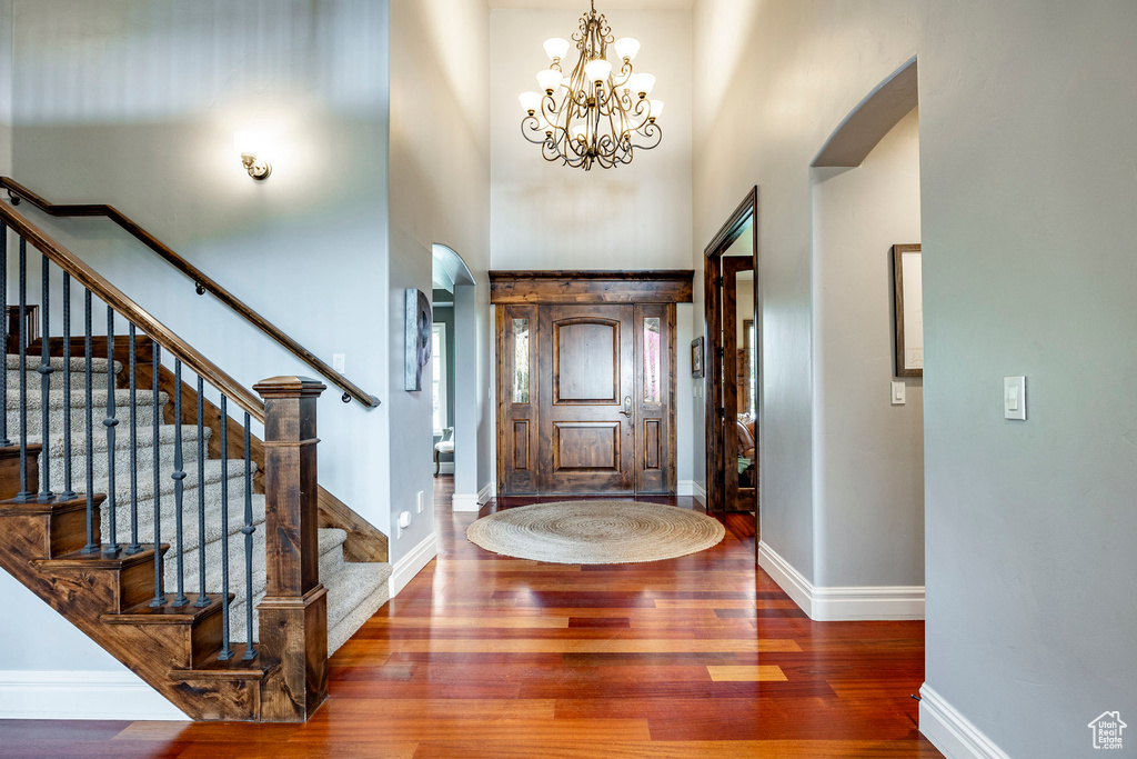 Foyer featuring a notable chandelier, a high ceiling, and dark hardwood / wood-style flooring