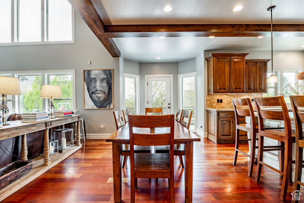 Dining area with beamed ceiling and hardwood / wood-style floors