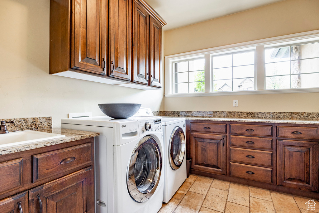 Laundry area with washer hookup, washer and clothes dryer, cabinets, and light tile floors