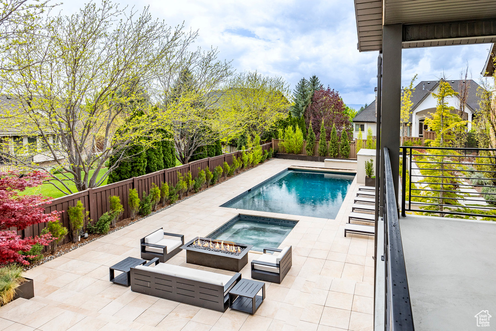 View of pool featuring a fire pit, an in ground hot tub, and a patio area