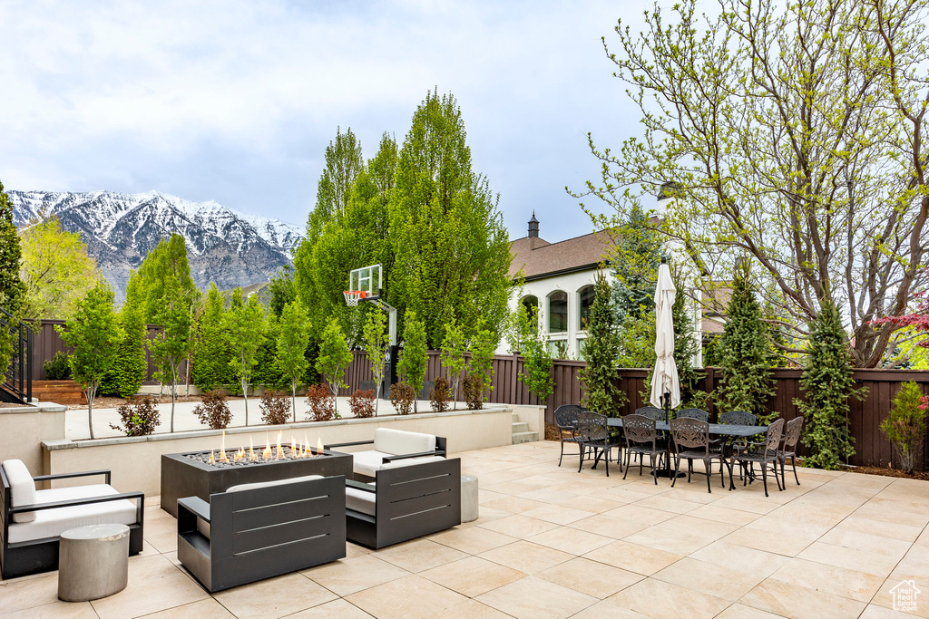 View of patio featuring a mountain view and an outdoor living space with a fire pit