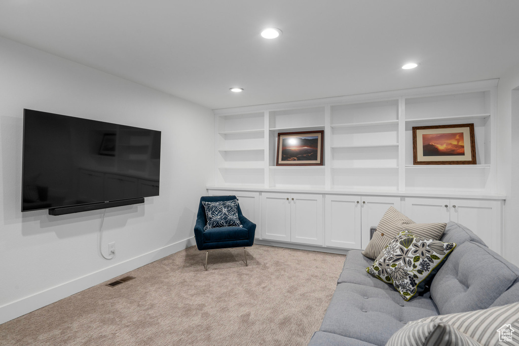 Carpeted living room with built in shelves