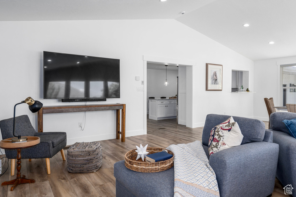 Living room featuring wood-type flooring and vaulted ceiling