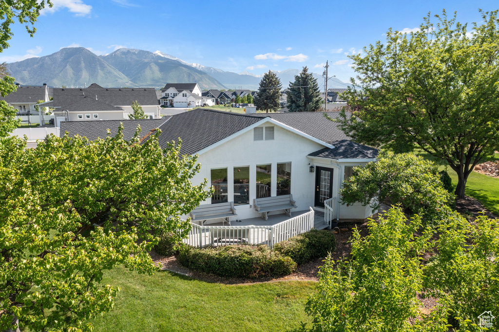 Rear view of house featuring a mountain view and a yard