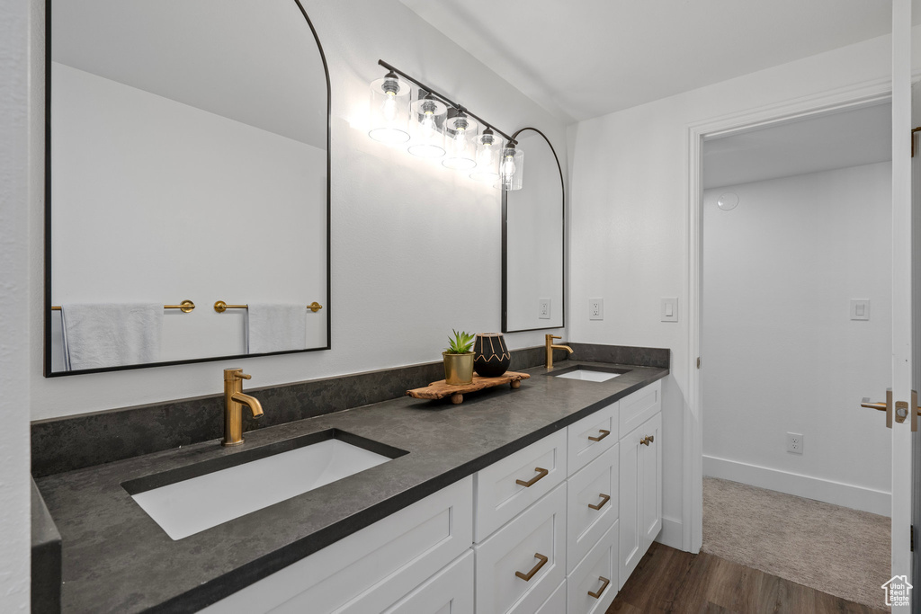 Bathroom with dual vanity and hardwood / wood-style floors