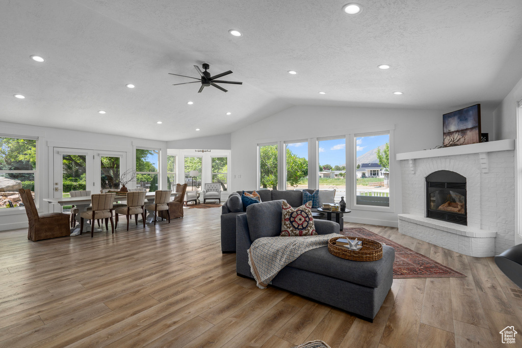 Living room with hardwood / wood-style floors, french doors, a fireplace, and lofted ceiling