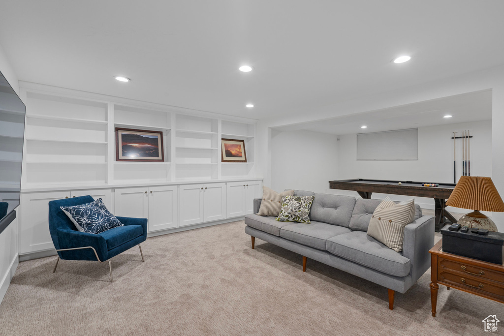 Living room featuring pool table, built in shelves, and light colored carpet