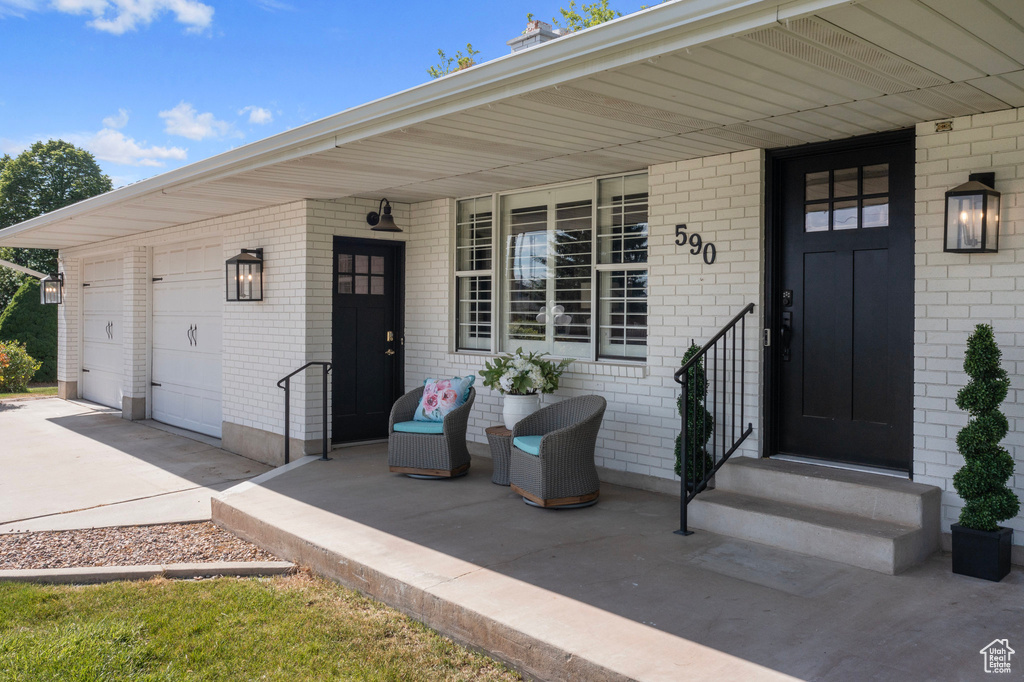 Property entrance with covered porch and a garage