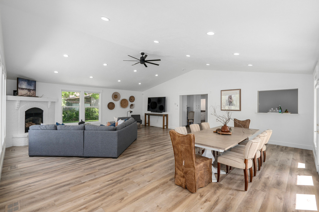 Dining room with ceiling fan, light hardwood / wood-style floors, and lofted ceiling