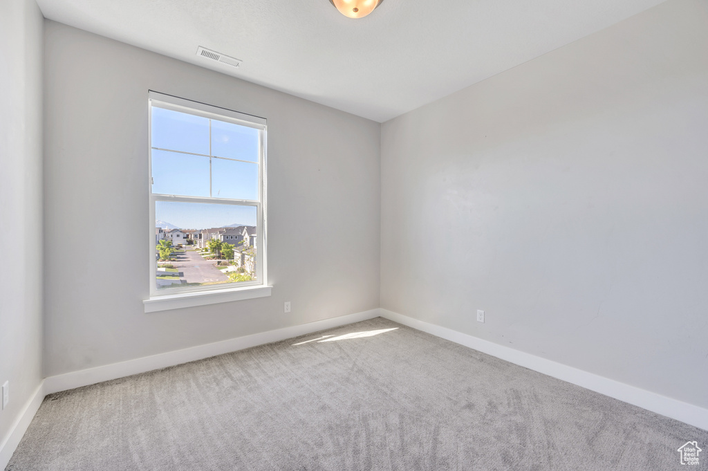 Unfurnished room featuring a wealth of natural light and carpet flooring