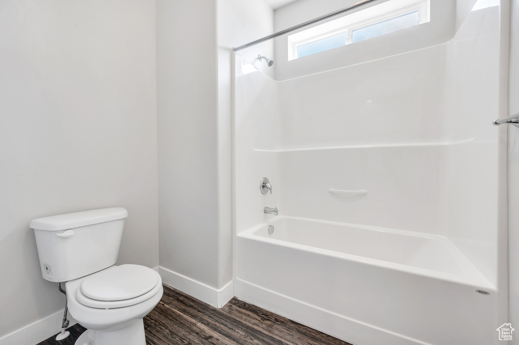 Bathroom featuring toilet, hardwood / wood-style flooring, and tub / shower combination