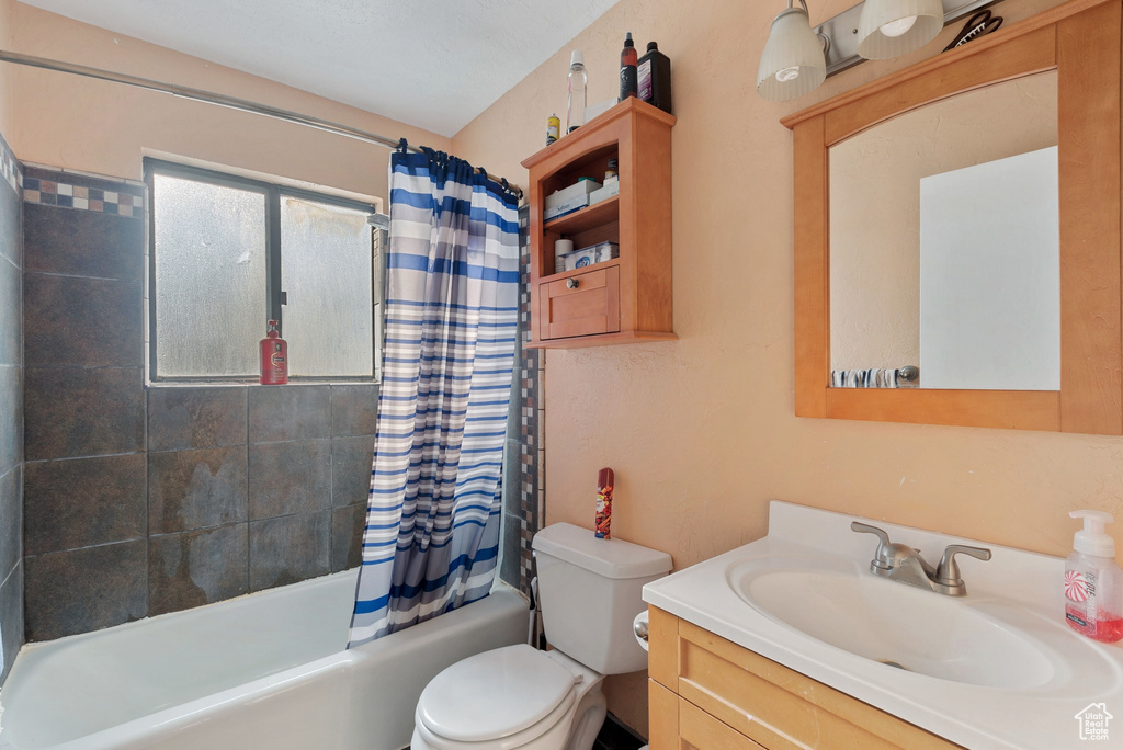 Full bathroom featuring shower / tub combo with curtain, toilet, and large vanity