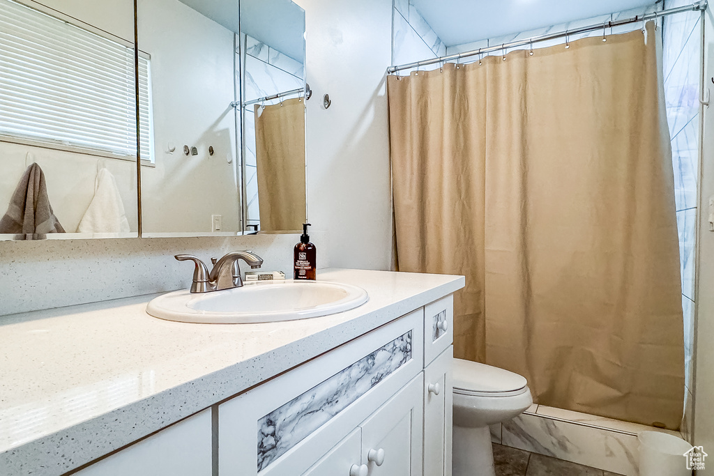 Bathroom featuring tile flooring, vanity, and toilet