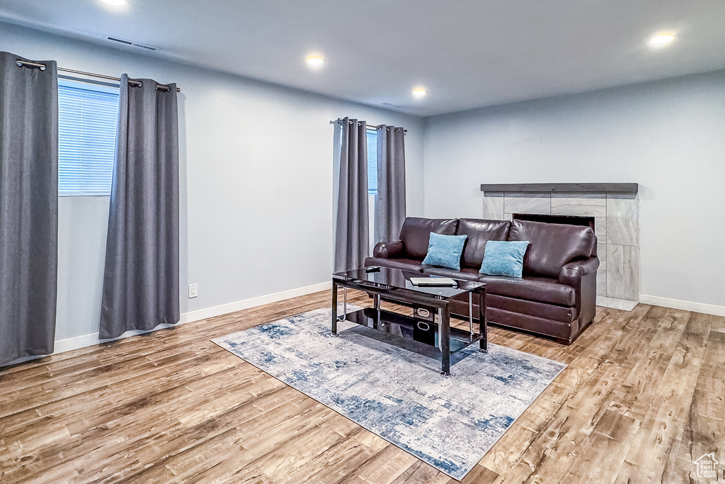 Living room with hardwood / wood-style floors and a tile fireplace