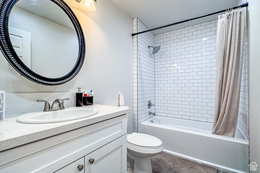 Full bathroom with toilet, shower / tub combo, and oversized vanity