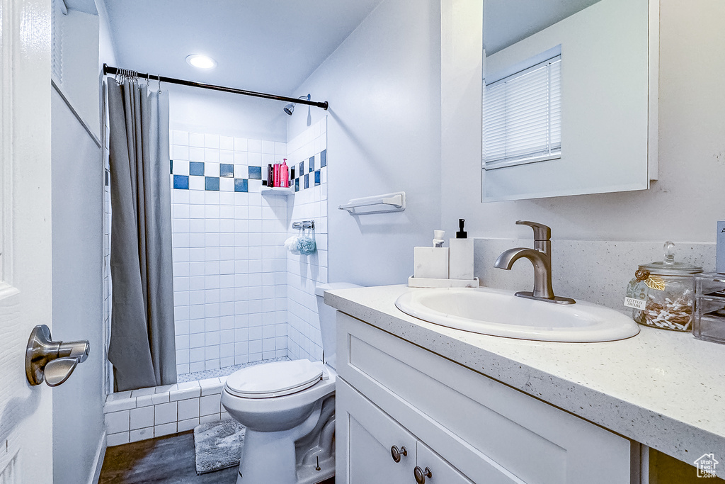 Full bathroom featuring toilet, oversized vanity, and shower / bath combo with shower curtain