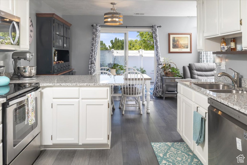 Kitchen featuring stainless steel appliances, sink, dark hardwood / wood-style flooring, and white cabinets