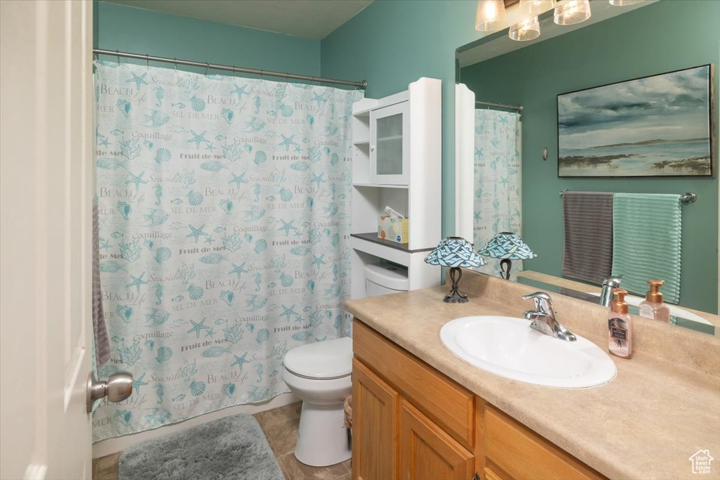 Bathroom featuring tile floors, oversized vanity, and toilet