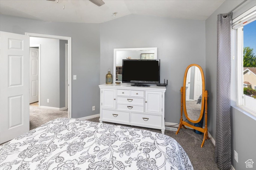 Bedroom featuring ceiling fan, vaulted ceiling, and light colored carpet