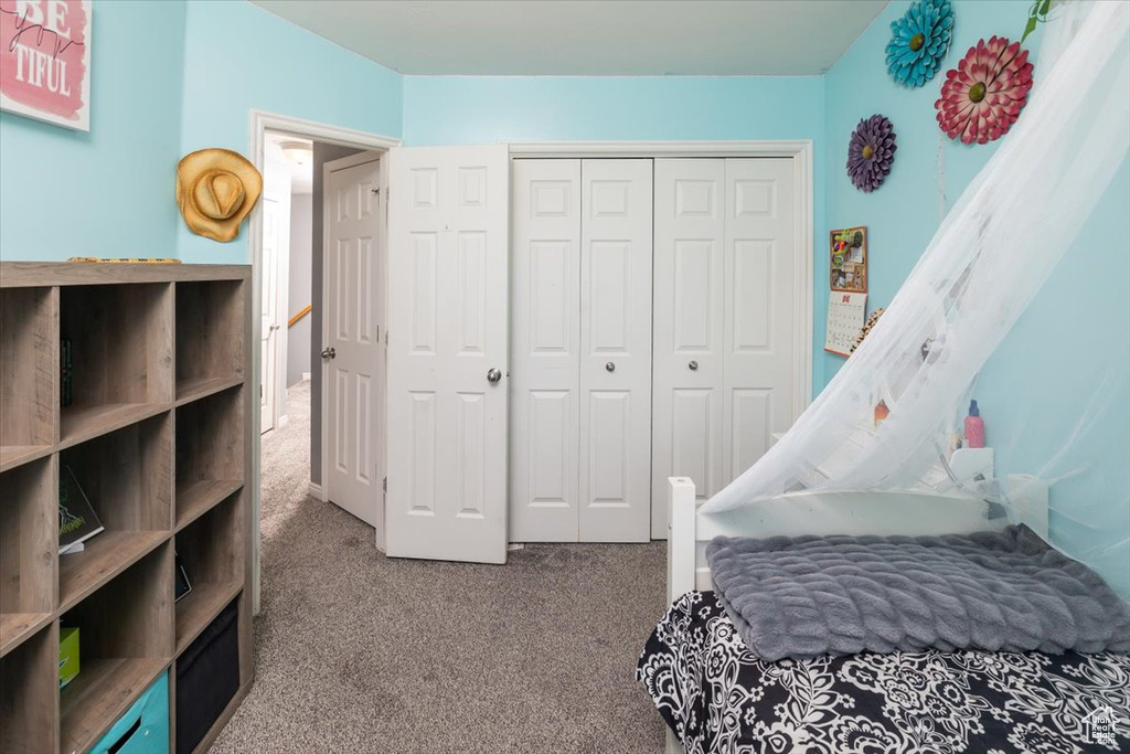 Bedroom featuring carpet and a closet