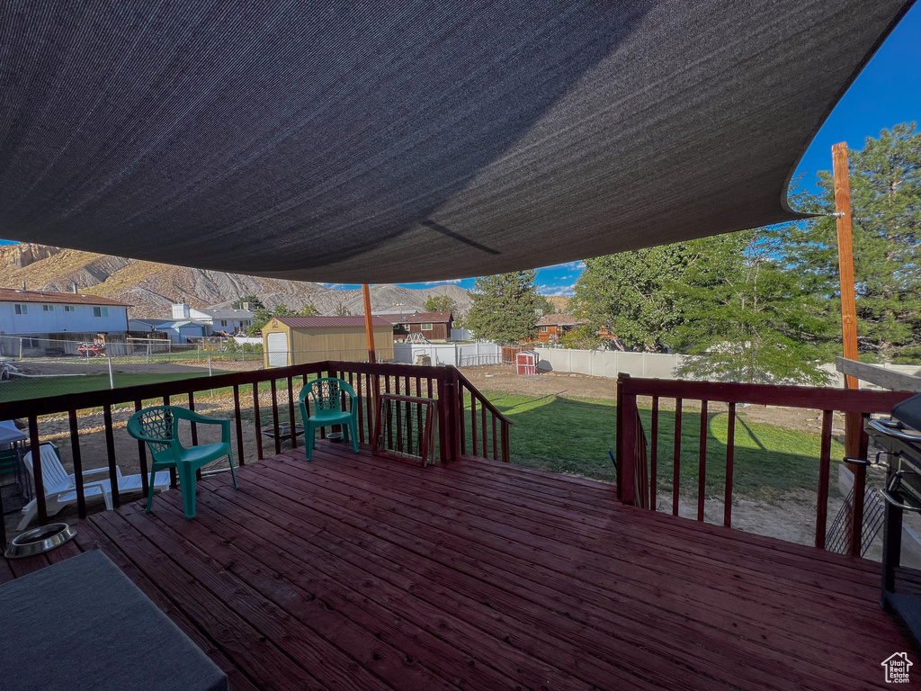 Deck featuring a shed and a yard