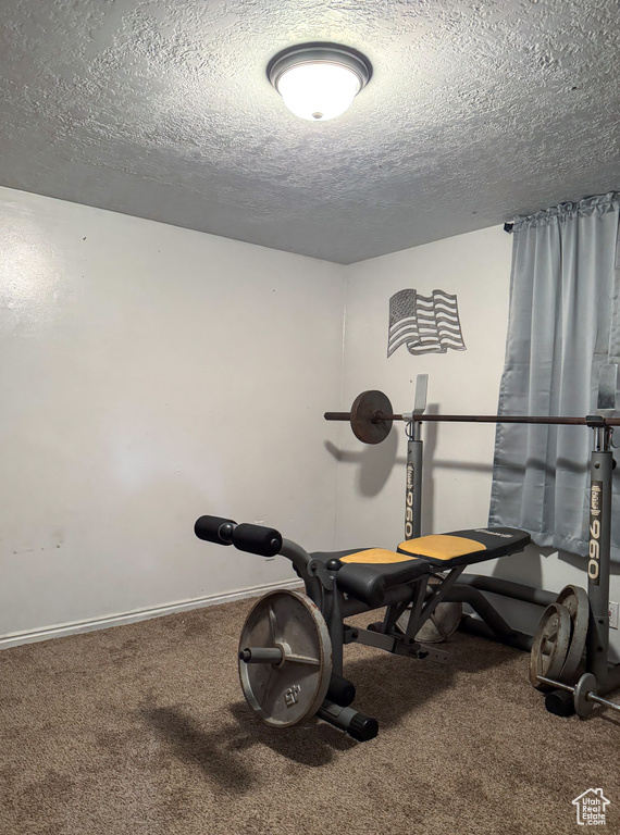 Workout room with carpet floors and a textured ceiling