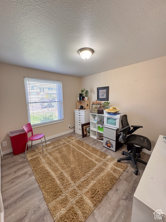 Office area featuring wood-type flooring and a textured ceiling