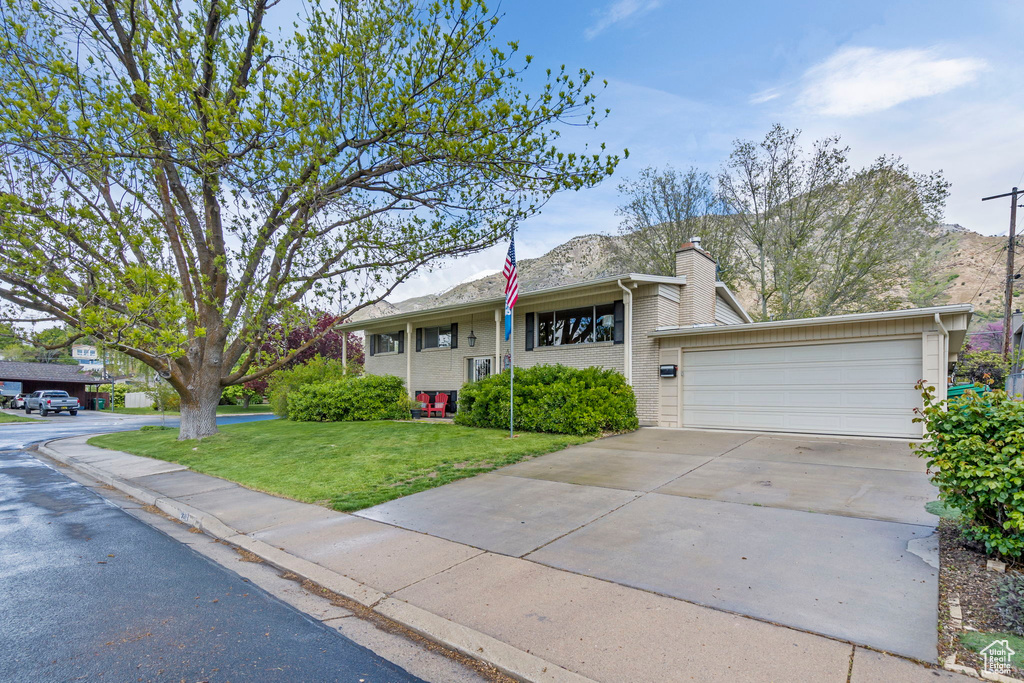 View of front of house featuring a garage and a front lawn