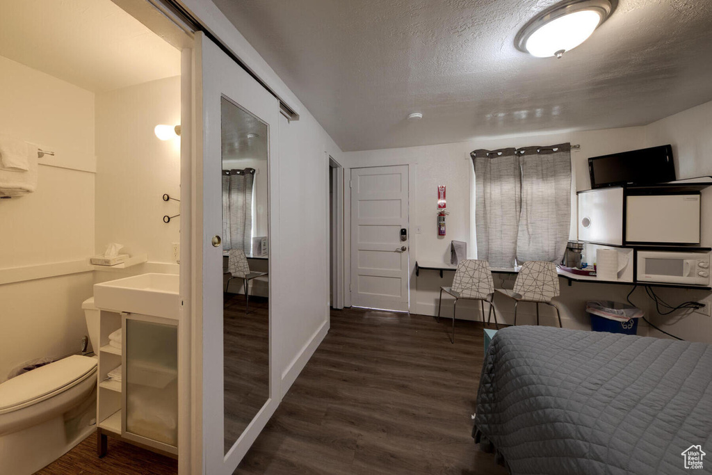 Bedroom featuring dark hardwood / wood-style flooring and ensuite bath