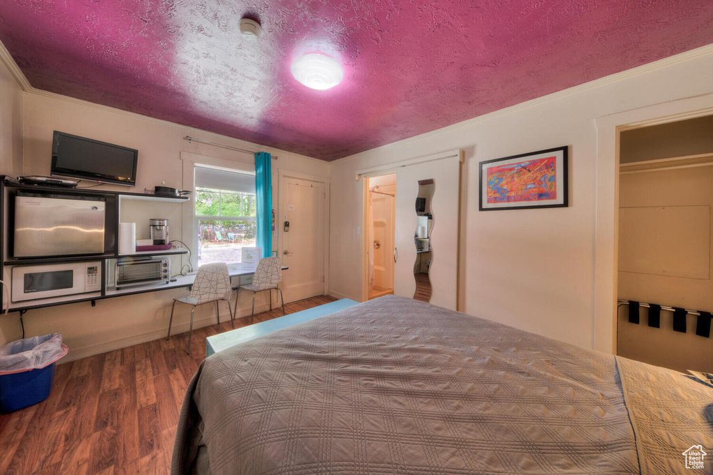 Bedroom with hardwood / wood-style floors and ornamental molding