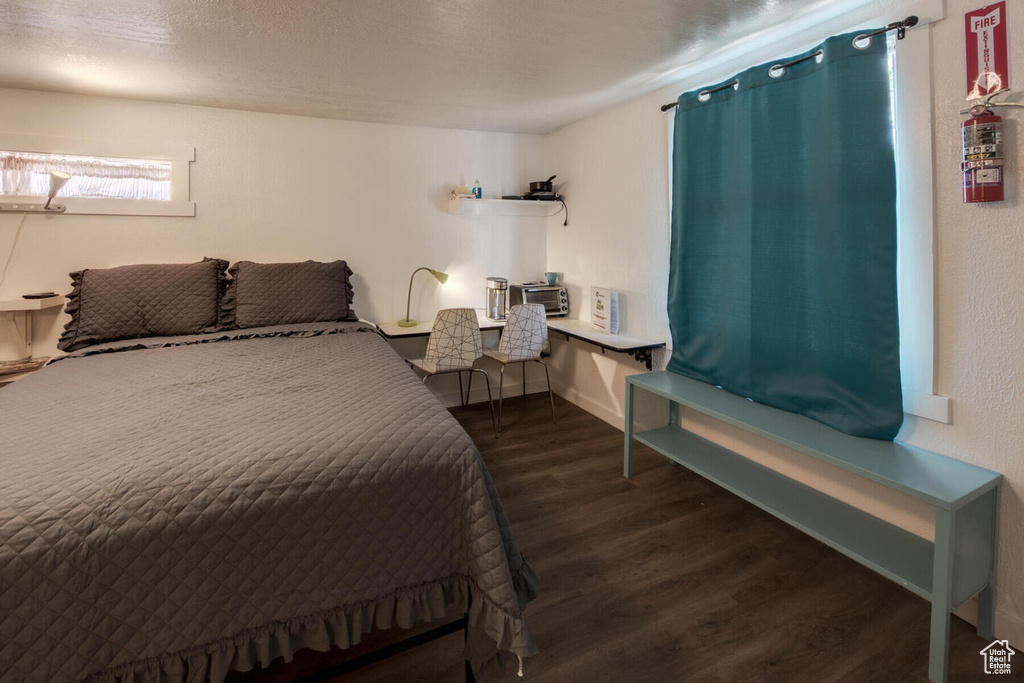 Bedroom featuring a textured ceiling and dark hardwood / wood-style flooring