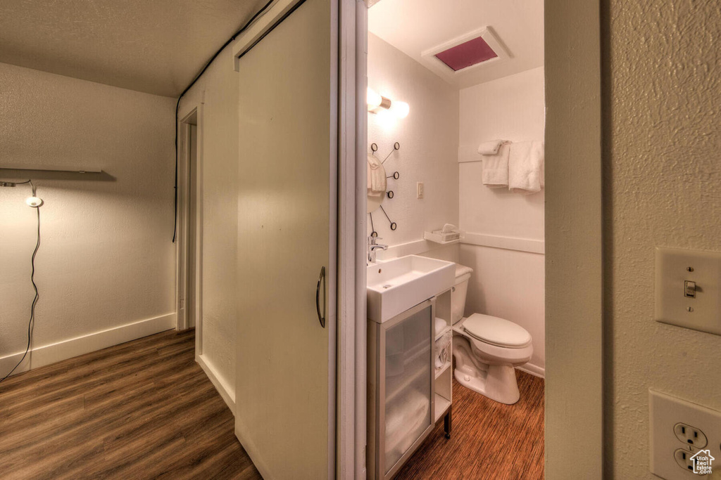 Bathroom featuring sink, a textured ceiling, toilet, and wood-type flooring