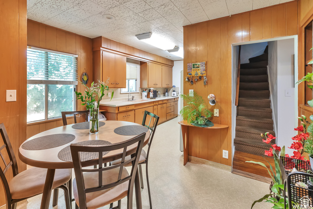 Dining space with a healthy amount of sunlight, sink, and wooden walls