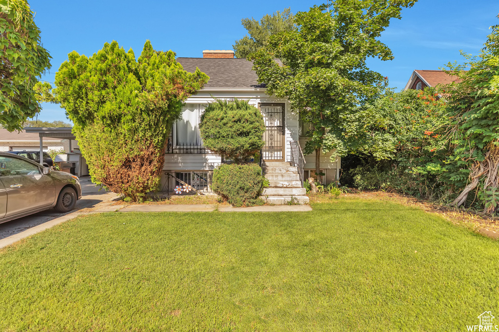 View of front of house featuring a carport and a front lawn