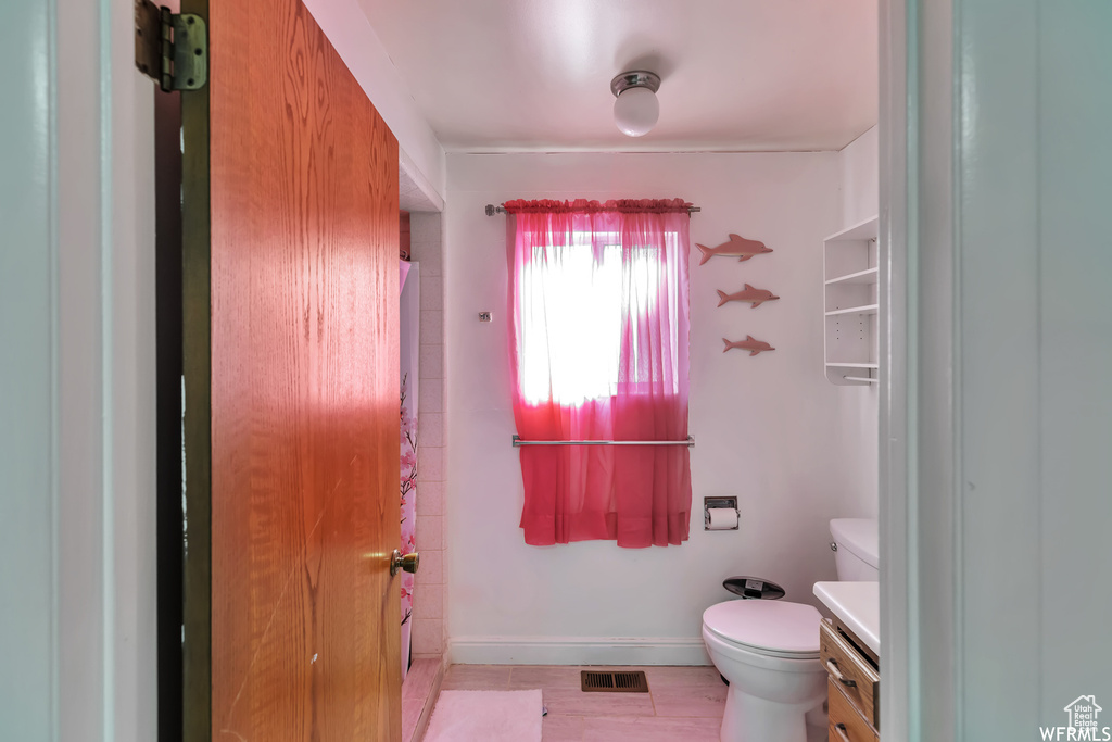 Bathroom featuring vanity, toilet, and tile floors