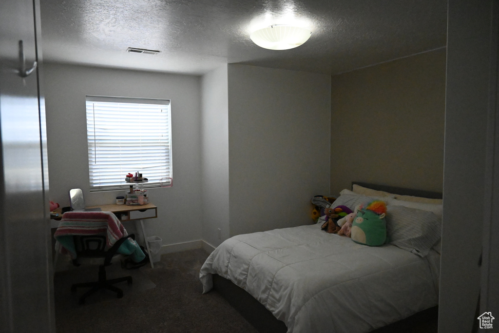 Carpeted bedroom with a textured ceiling