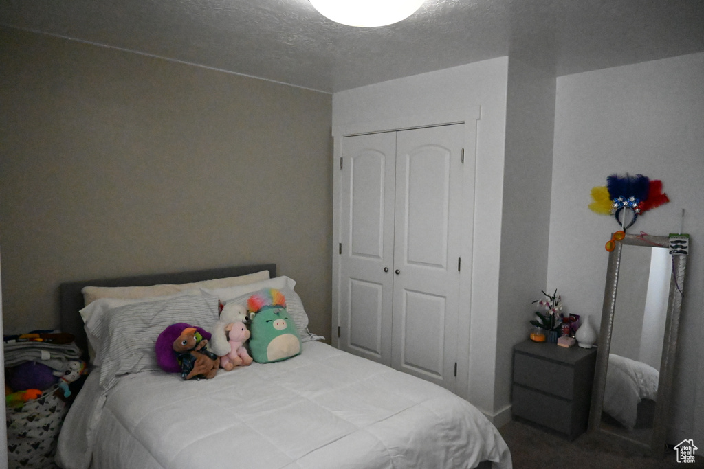 Bedroom with a closet, a textured ceiling, and carpet flooring