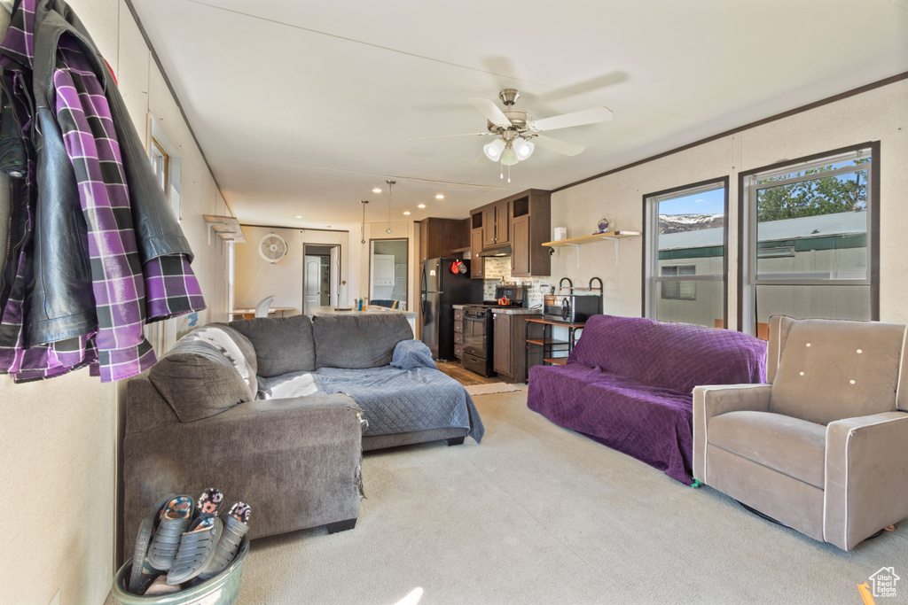 Carpeted living room with ceiling fan