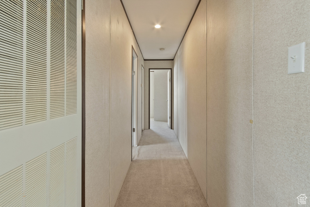 Hallway featuring light carpet