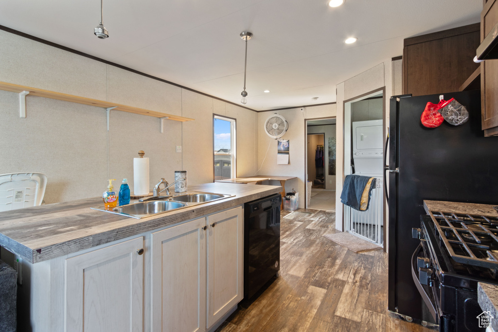 Kitchen featuring butcher block countertops, pendant lighting, wood-type flooring, black dishwasher, and sink