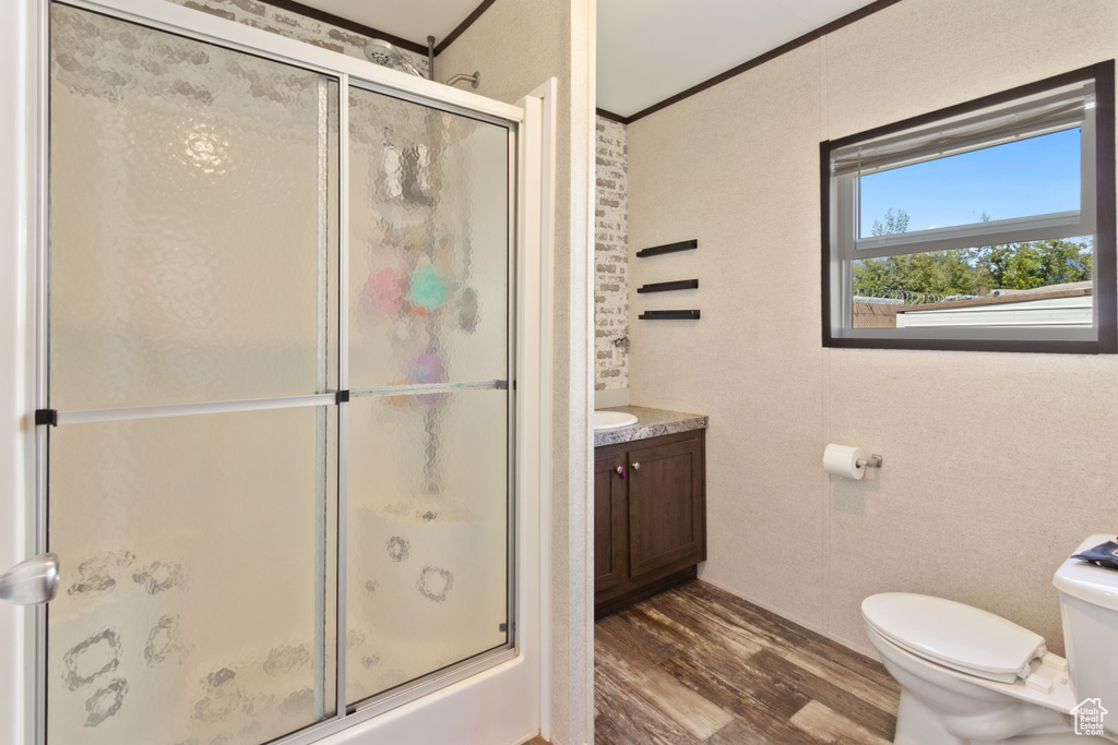 Bathroom featuring wood-type flooring, vanity, toilet, and ornamental molding