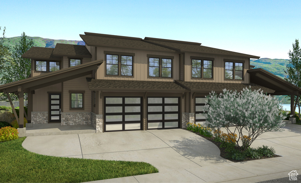 View of front of property with a garage and a mountain view