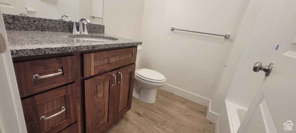 Bathroom with toilet, vanity, and hardwood / wood-style flooring