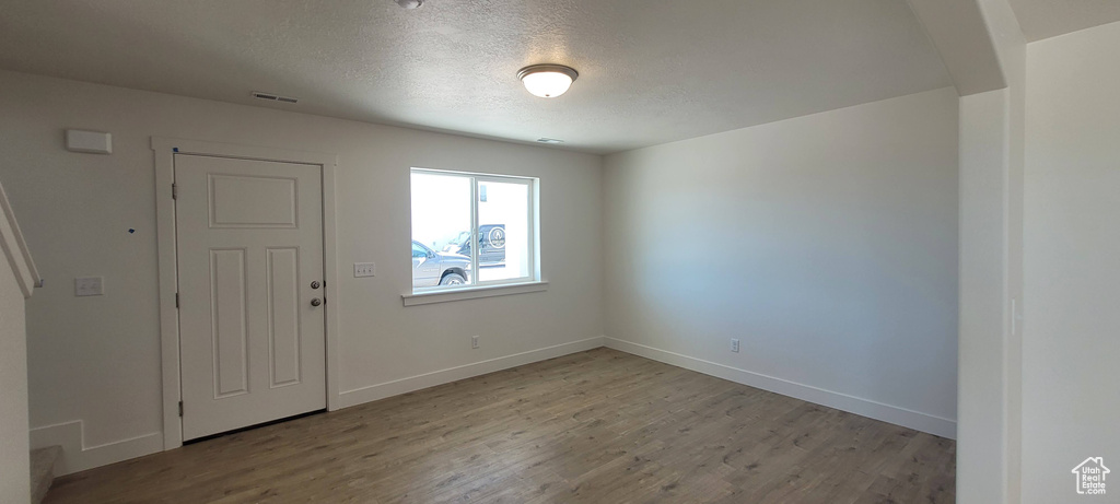 Spare room featuring hardwood / wood-style flooring and a textured ceiling