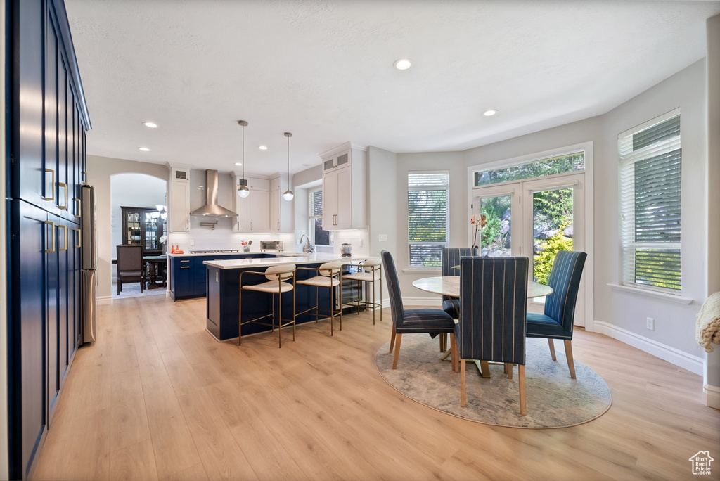 Dining area with light hardwood / wood-style floors and french doors