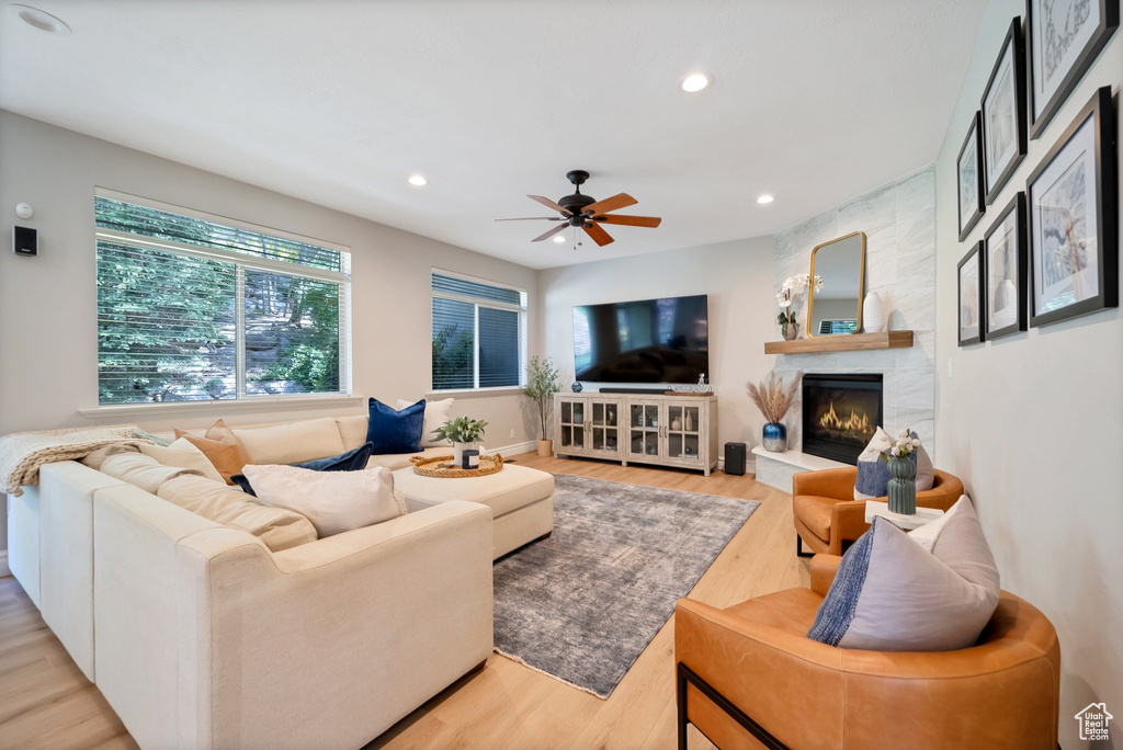 Living room featuring light hardwood / wood-style floors, a fireplace, and ceiling fan