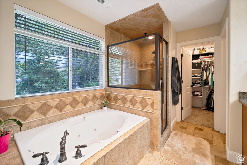 Bathroom featuring tile floors and plus walk in shower