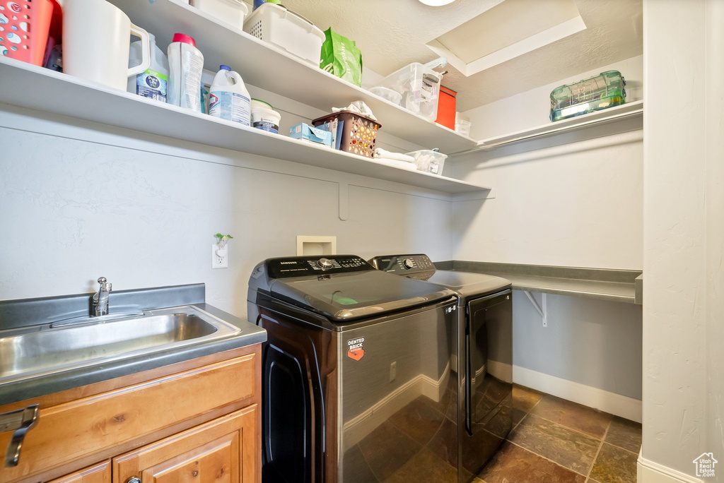 Washroom featuring cabinets, washer hookup, independent washer and dryer, sink, and dark tile flooring