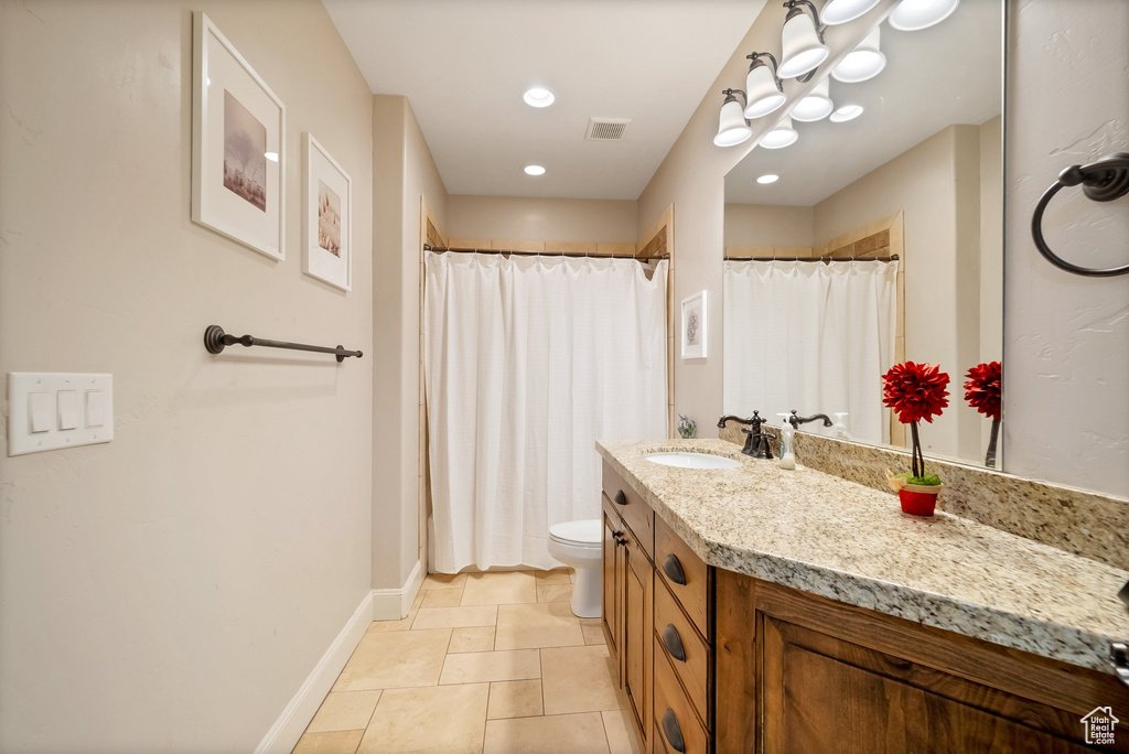 Bathroom featuring tile flooring, vanity, and toilet